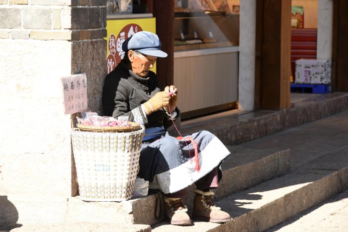 麗江街邊大爺手工編織納西族藥包